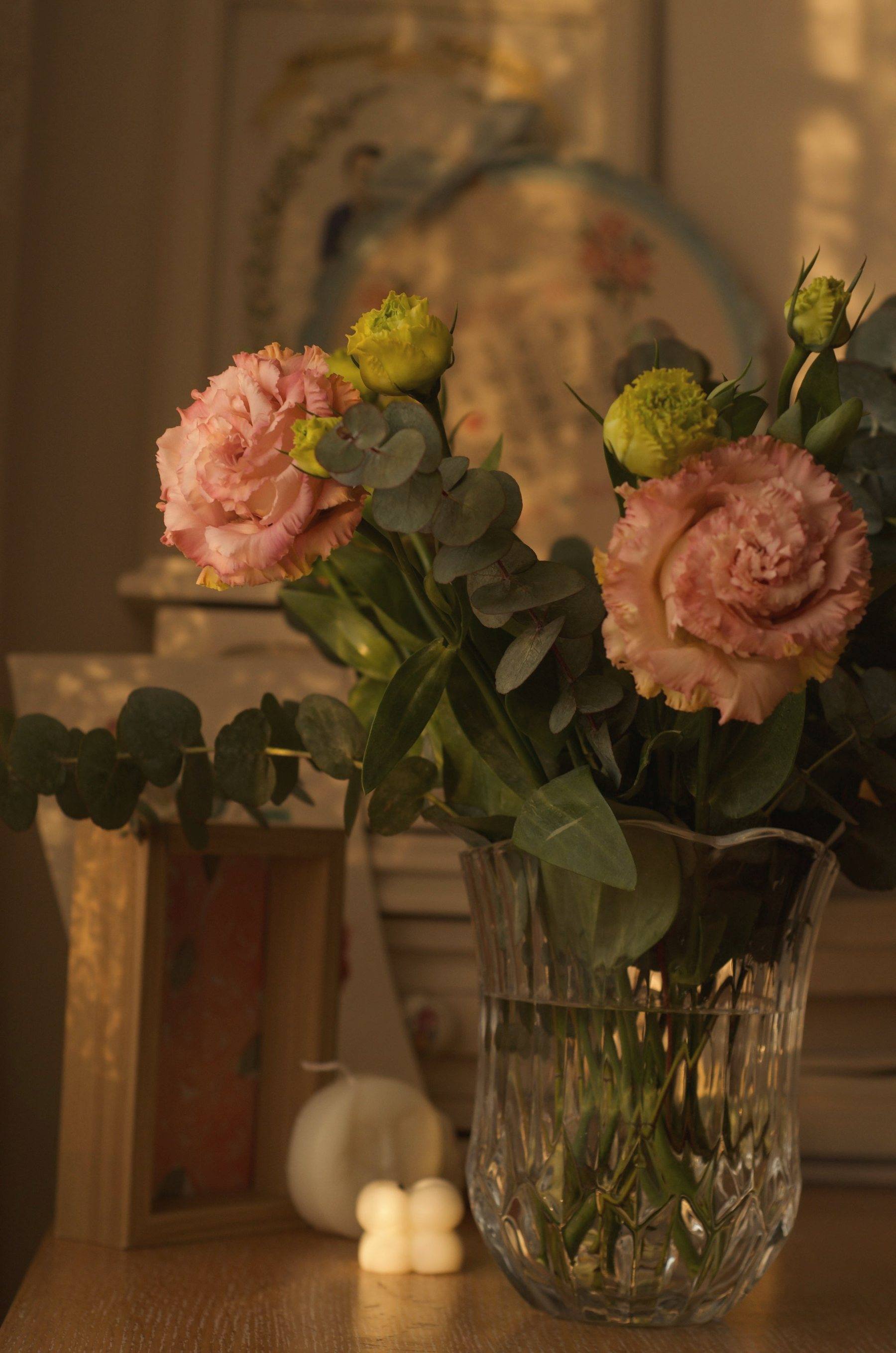 Peach roses in a crystal vase in warm light
