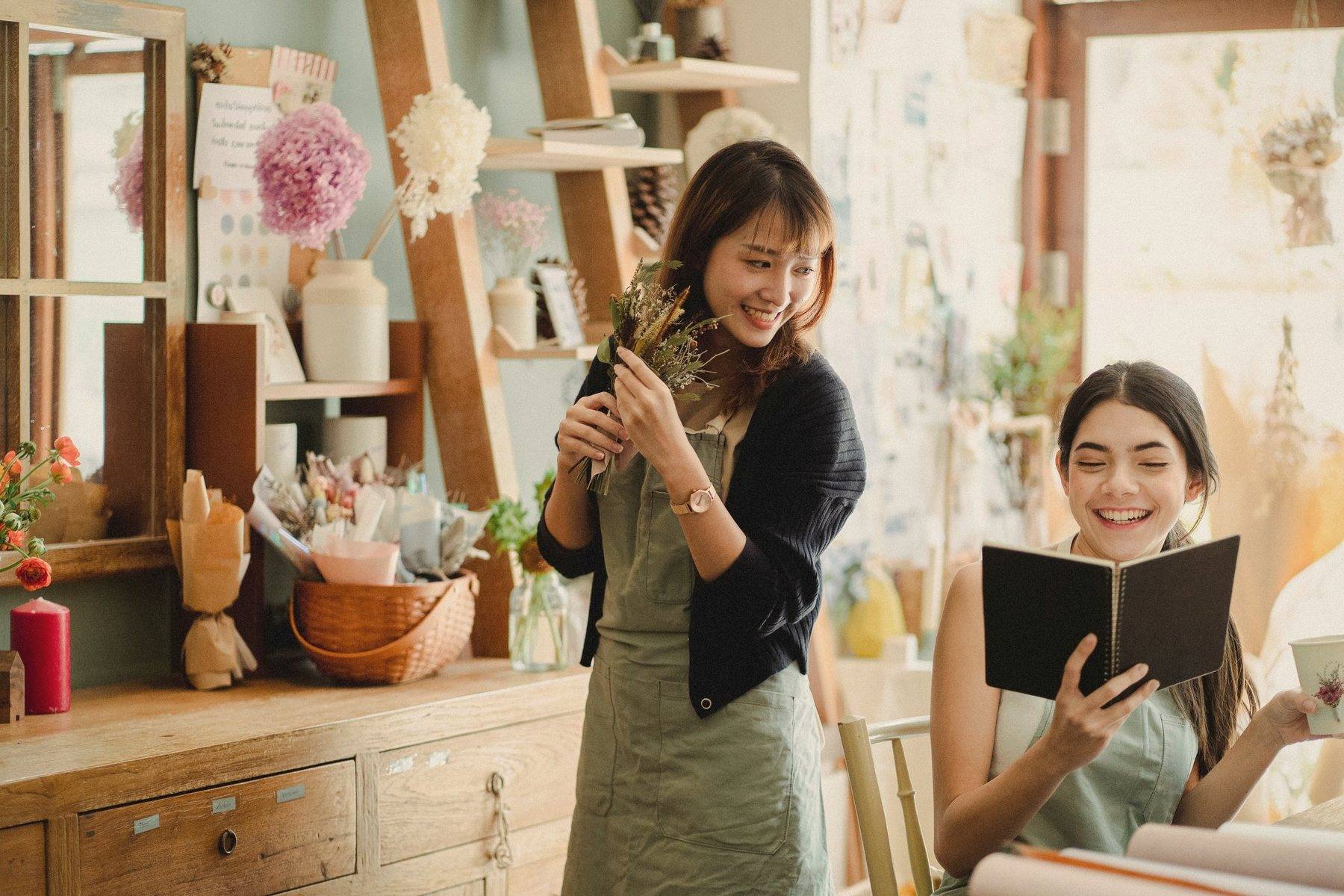 Friends laughing together among flowers in a bright studio